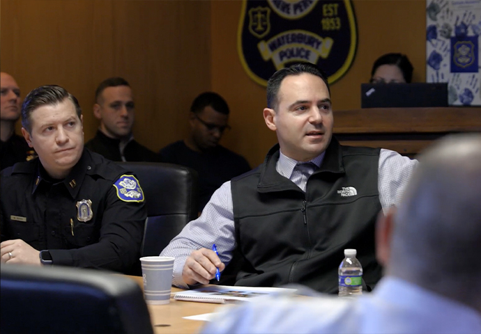 Waterbury Police personnel in a professional meeting with the department seal visible